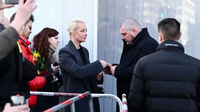 Yulia Navalnaya shows her passport at the control point at the Russian embassy in Berlin.