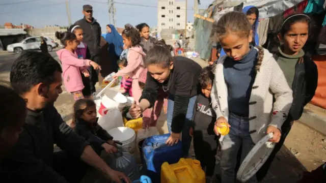 Palestinian children wait with bottles in line to get water amid clean water and food crisis from mobile storages of charities as they have limited access to water due to Israeli attacks and imposed blockade in Rafah, Gaza on March 16, 2024