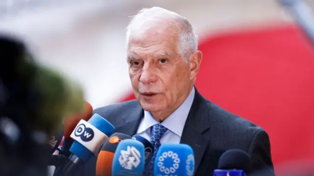 Up close shot of Josep Borrell speaking into several microphones at a press conference