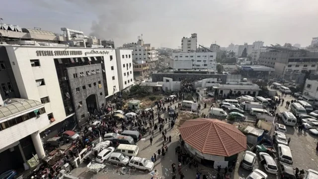 A photo from above of the hospital - the area in front of it is swarming with cars and people