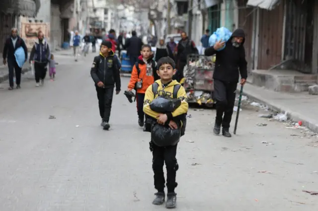 Palestinian residents leave the area with a few items after the Israeli army forces besiege the Al-Shifa hospital with tanks and heavy gunfire in Gaza City, Gaza on March 18, 2024