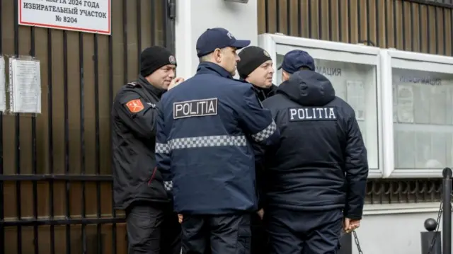 Police officers guard during Russian presidential elections in front of the Russian Embassy in Chisinau, Moldova