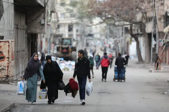 Palestinian residents leave the area with a few items after the Israeli army forces besiege the Al-Shifa hospital with tanks and heavy gunfire in Gaza City, Gaza on March 18, 2024