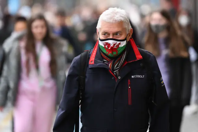 A man wears a Wales face mask walking through Cardiff