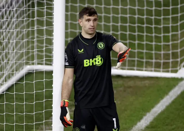 Martinez waves instructions to his defenders while leaning on the post.