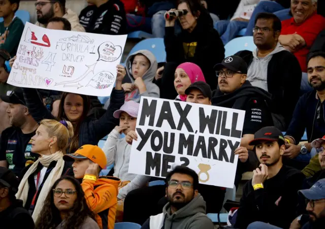 fan holds a 'Max will you marry me' sign