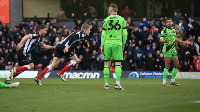 Grimsby players celebrate scoring against Forest Green Rovers