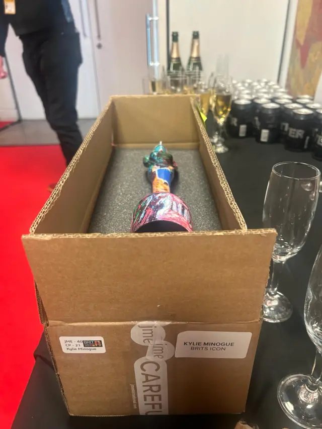 Box holding aware next to champagne glasses