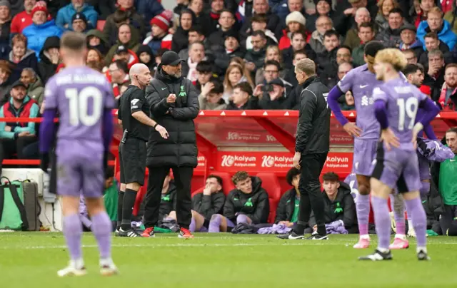 Klopp argues with the officials as his players watch on.