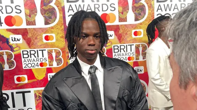 Rema speaks to Mark Savage on the red carpet