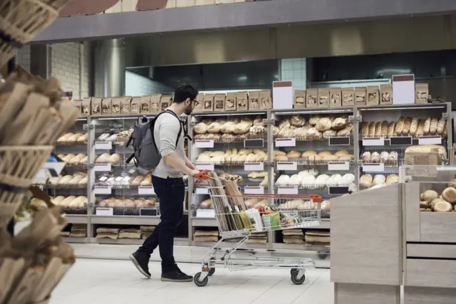 Man in supermarket bread aisle - stock shot