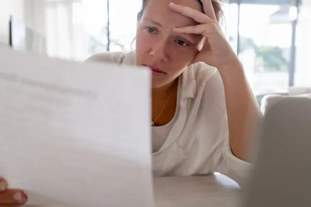 Woman looks at bill - stock shot