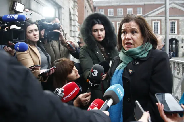 Mary Lou McDonald with lots of microphones and cameras pointed at her