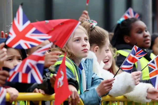 Large groups of children are waiting to see Queen Camilla