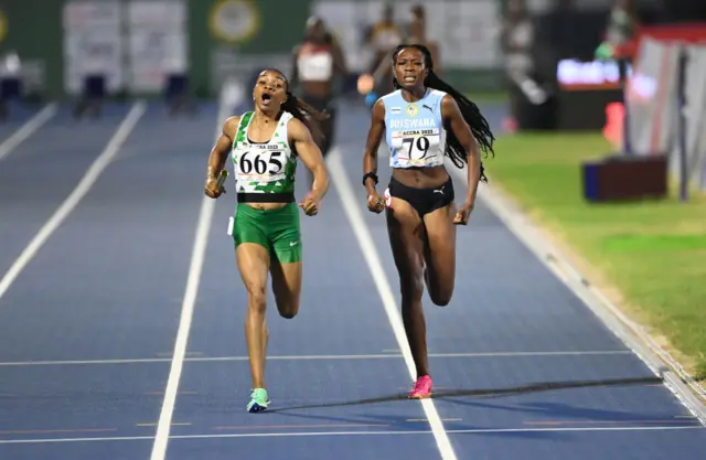 Nigeria's Omolara Grace Ogunmankinju (L) and Botswana's Obakeng Kamberuka (R) compete during the 4X400m mixed relay