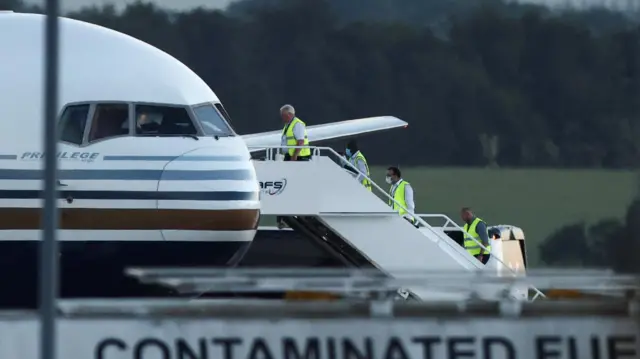 Members of the staff board a plane