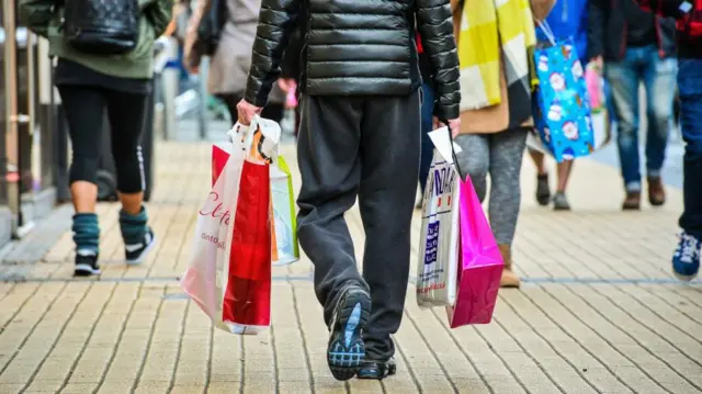 Man carrying bags in the Broadmead shopping area of Bristol.