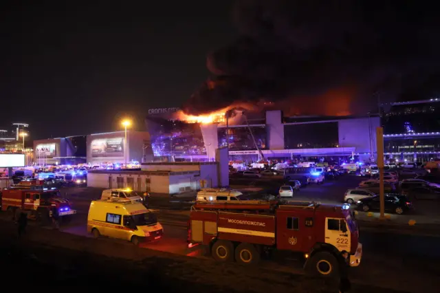 Emergency services vehicles are seen outside the burning Crocus City Hall concert hall following the shooting incident in Krasnogorsk, outside Moscow.