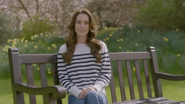 Catherine sits on a bench in front of spring bulbs