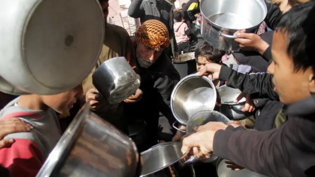 Palestinians gather to receive free food as Gaza residents face crisis levels of hunger, during the holy month of Ramadan, amid the ongoing conflict between Israel and Hamas, in Jabalia in the northern Gaza Strip March 19, 2024.