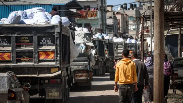 Trucks carrying humanitarian aid make their way along a street in Rafah in the southern Gaza Strip, on March 10, 2024, amid the ongoing conflict between Israel and the Hamas movement