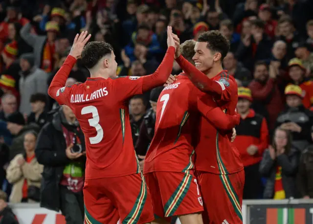 Brennan Johnson celebrates with his Wales team-mates after scoring