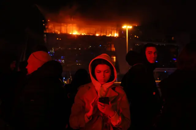 People outside the burning concert hall