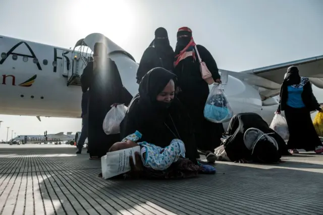 Ethiopians women repatriated from Saudi Arabia react as they disembark from the airplane at the Bole Airport, in Addis Ababa, on March 30, 2022.