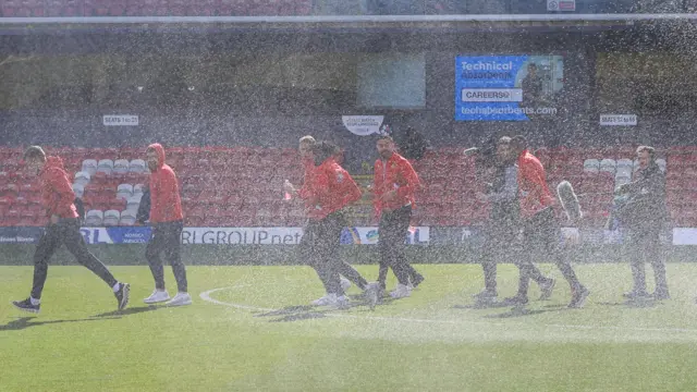 Wrexham players caught by a sprinkler during pitch walk at Grimsby