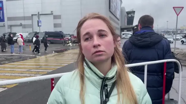 Eyewitness Margarita stands next to a cordon near the concert hall