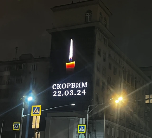 A billboard in Moscow showing a candle and the word "skorbim", meaning "we mourn"