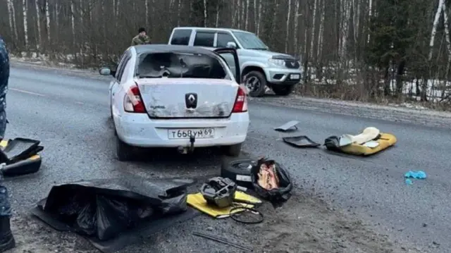 A white Renault car stopped diagonally across a road