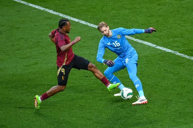 Republic of Ireland goalkeeper Caoimhin Kelleher in action against Loïs Openda of Belgium