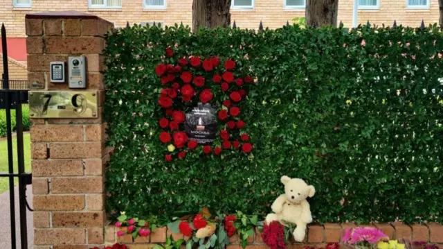 Flowers and candles against a wall and garden