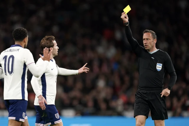 England's Jude Bellingham (left) is shown a yellow card by Match referee Artur Manuel Soares Dias