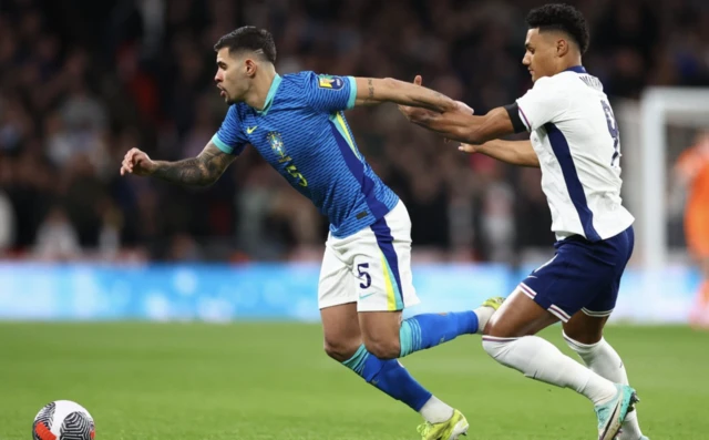 Brazil's Bruno Guimaraes in action with England's Ollie Watkins