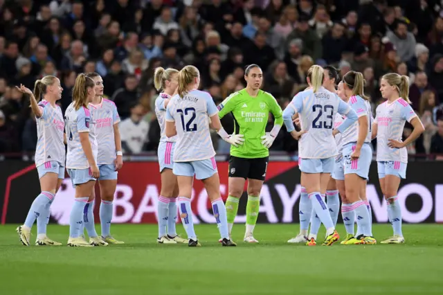 Arsenal players stand to discuss tactics after conceding