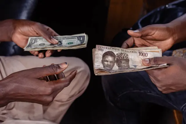 A customer exchanges Nigerian 1000 Naira banknotes for US dollar banknotes with a street currency dealer at a market in Lagos, Nigeria, on Monday, Sept. 25, 2023.