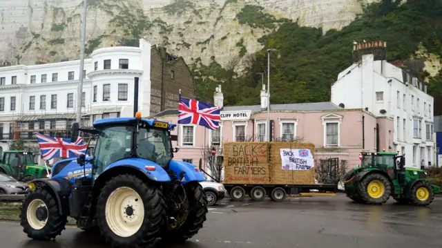 Farmers using their vehicles to protest against cheap meat imports drive past the Port of Dover in Kent