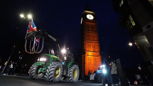 Tractors in front of the Elizabeth Tower at night