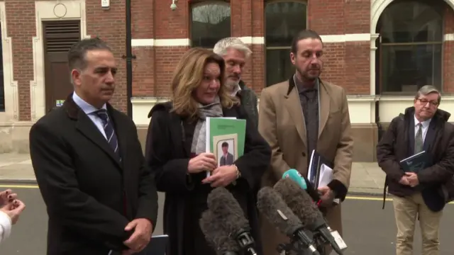 Emma Webber, holding a photograph of her son Barnaby, and her legal team speak to reporters