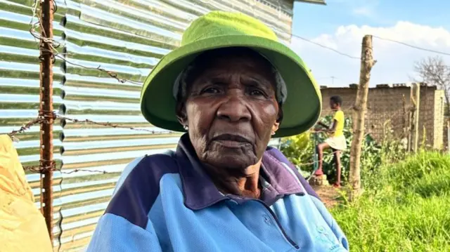 Lala Maria Sebetlele outside her shack in Soweto, South Africa