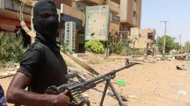 A member of Sudanese armed forces looks on as he holds his weapon in the street in Omdurman, Sudan, March 9, 2024