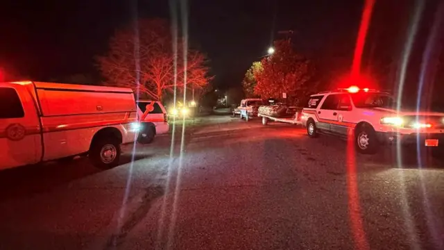 Emergency service vehicles parked on the road side flashing red lights