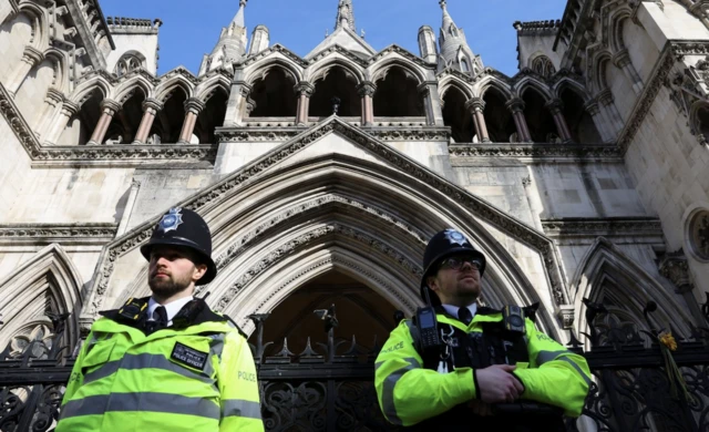 Police officers stand guard ouside the High Court, on the day it is set to rule on whether Julian Assange can appeal against extradition from Britain to the United States,