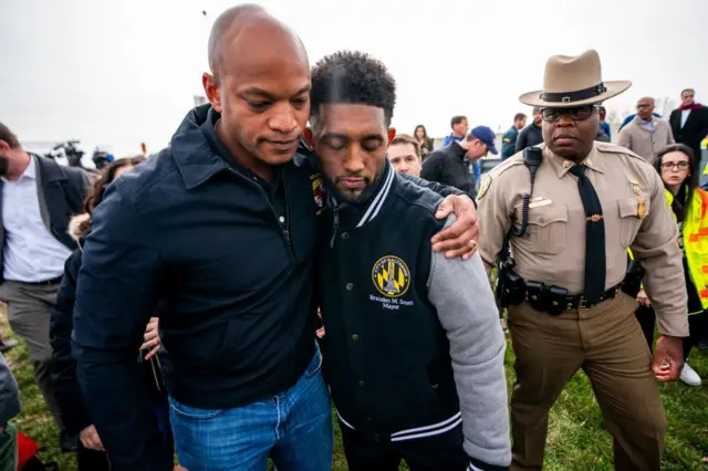 Maryland Governor Wes Moore (L) and Baltimore Mayor Brandon Scott (C) react following a press conference at the scene of the Francis Scott Key Bridge collapse in Baltimore, Maryland, USA, 26 March 2024