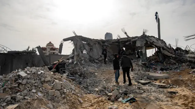 Palestinians inspect the ruins of there home destroyed in an air strike