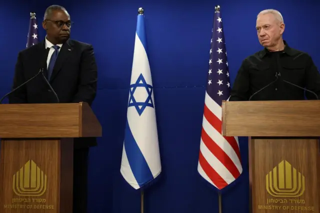 US defence secretary Lloyd Austin (left) and Israeli defence minister Yoav Gallant stand in front of an Israeli and a US flag at a press conference in Tel Aviv in December 2023