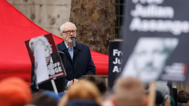 Corbyn addresses a crowd through a microphone