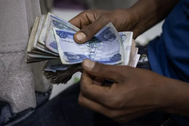 A shop owner counts Ethiopian Birr in his stall at the Shola Market in Addis Ababa on December 4, 2023.